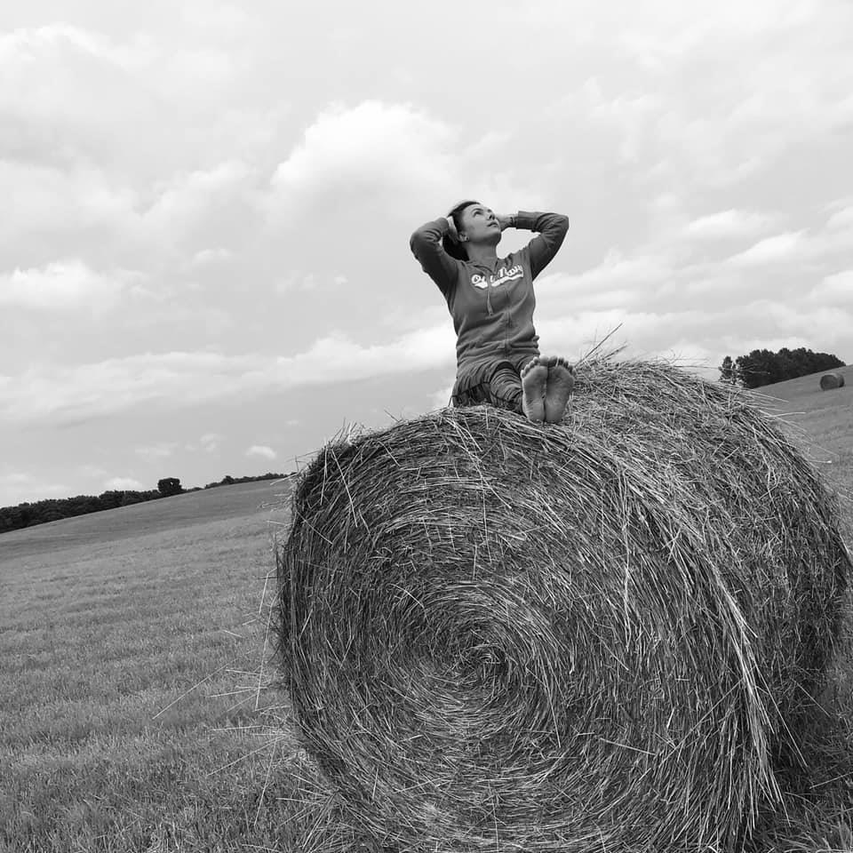 Woman rising confidently on a hay bale